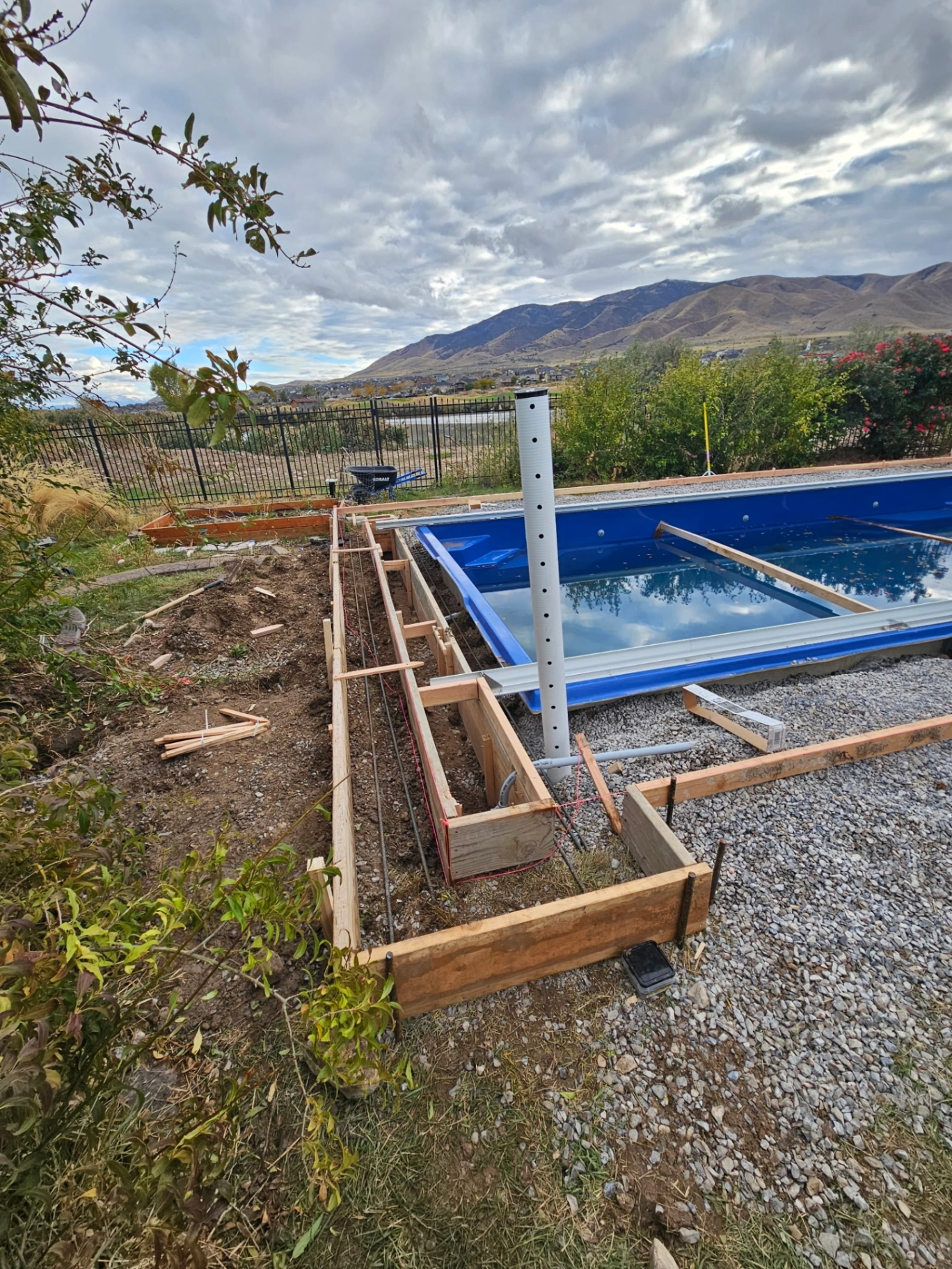 Step 2 — Plumbing runs and deck footing forms built around the set shell