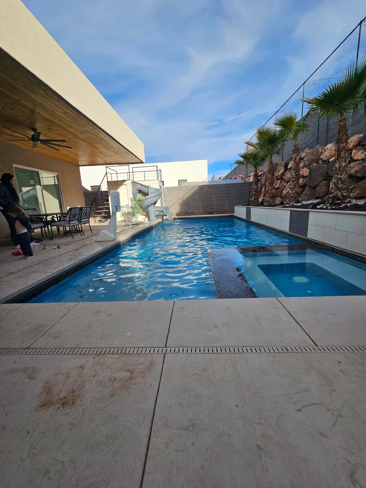 Premium pool and spa combo with slide, tile accents, and covered patio