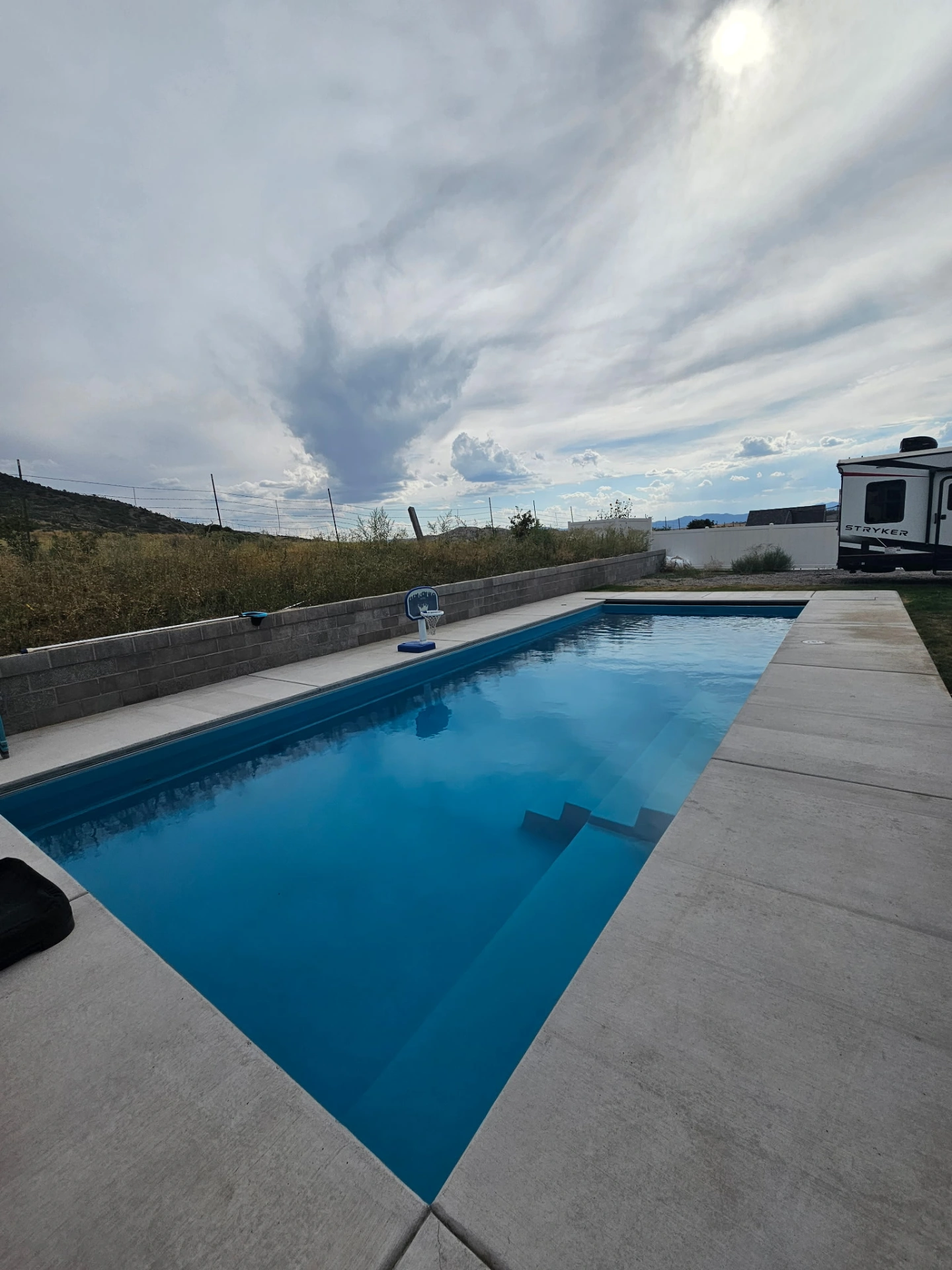 Spacious rectangular fiberglass pool with wide concrete surround