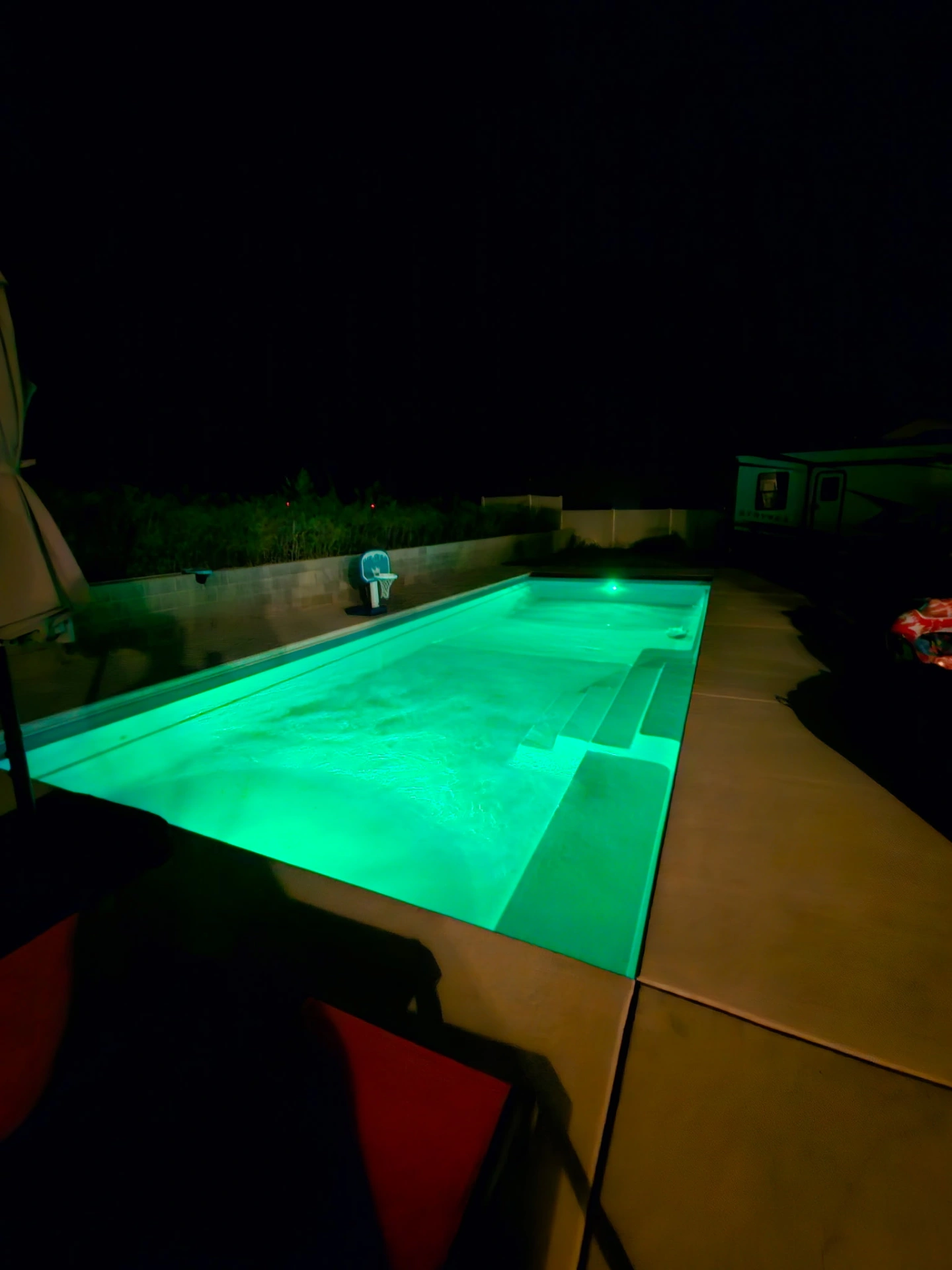 Pool illuminated in vibrant green for evening ambiance