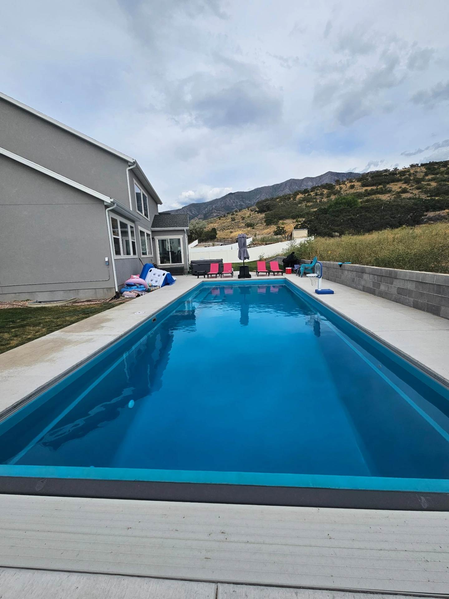Long lap-style fiberglass pool framed by mountain views