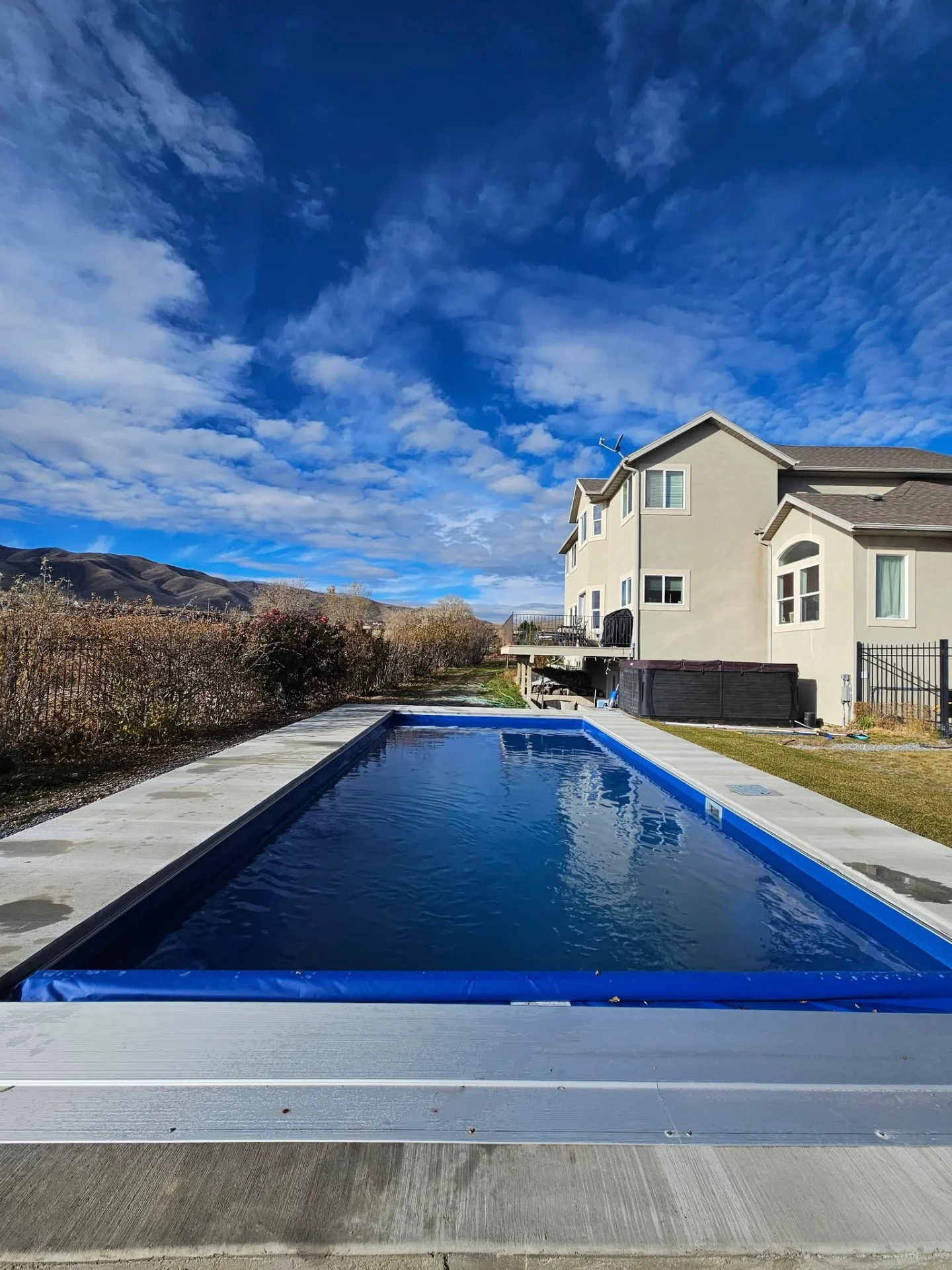 Finished lap pool with automatic safety cover and poured concrete surround